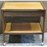 A retro teak two tier tea trolley of rectangular form and fitted with a through frieze drawer within