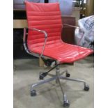 An Eames style swivel office desk chair with stitched pad seat within a chrome and cast alloy