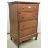A small Edwardian mahogany chest of four long drawers raised on a low stand with shaped apron and