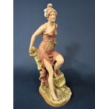 Early 20th century Royal Dux figure of a classical style female character perched on a rock, with