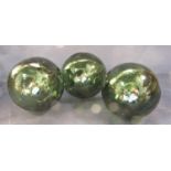 Three antique green glass buoys, 12 cm diameter