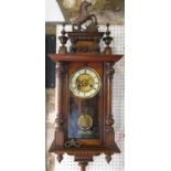 19th century German wall clock in walnut, the glazed case with column supports, set beneath a shaped