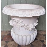 A cast or moulded plaster Campana shaped urn with flared egg and dart rim, tied ribbon floral swag