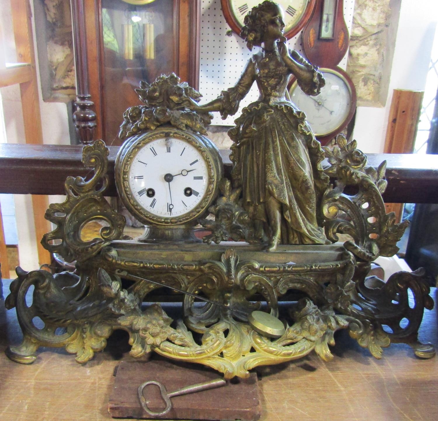 19th century gilt brass mantel clock in the romantic style, with female character floral bouquets,