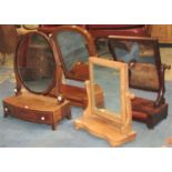 A small Georgian mahogany toilet mirror of oval form with shaped and moulded supports raised on a