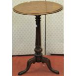 A Victorian mahogany games table, the circular top with chequered board detail, raised on turned and