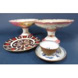 A matched pair of 19th century pink ground comports, one with reserved painted panels of chateaux,