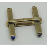 Single engine turned yellow metal cufflink with sapphire terminals, inscribed 'Asprey 1944', 3.9g