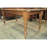A Victorian style stripped pine farmhouse kitchen table of rectangular form with moulded outline and