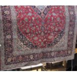 Large Hammadam carpet with typical central navy blue medallion framed by scrolled foliage upon a