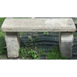 A reclaimed three sectional garden bench with slab seat and shaped supports, with Tudor or