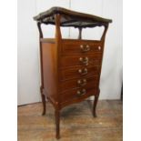 An inlaid Edwardian sheet music cabinet, the shaped top over an open alcove, the five drawers with
