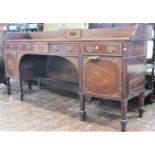 A Georgian mahogany sideboard of gentle bowfronted outline fitted with an arrangement of drawers and