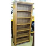 A contemporary light oak freestanding open shelving unit/bookcase with fixed shelves and panelled
