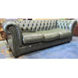 A traditional three seat Chesterfield sofa with buttoned dark green faux leather upholstered finish,