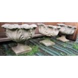 A set of three reclaimed garden urns, with circular cabbage leaf bowls and square cut bases,