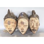 Tribal interest - African masks with whitened faces, carved detail and additional colours - lifesize
