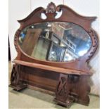 An Edwardian mahogany framed mirror with oval bevelled edge plate within a shaped frame with