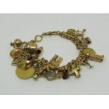 Good 18ct curb link charm bracelet hung with twenty-two novelty charms to include an owl with ruby