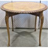 A good quality mixed wood occasional table of circular form with gadrooned outline raised on four