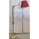 A brass coated floorstanding reading lamp with knopped tubular stem and adjustable swan neck