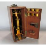 A brass and enamelled microscope of the Medical Supply Association with additional lenses in