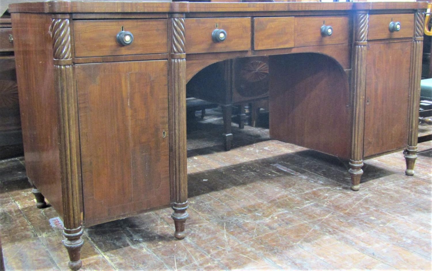 A William IV period inverted breakfront pedestal sideboard, with reeded column supports, enclosing