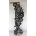 A carved Chinese hardwood figure showing God Of Longevity carrying peaches, sack, etc, with circular