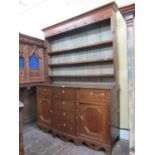 An early 19th century North Wales breakfront dresser, the base fitted with a T shaped arrangement of