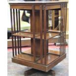 An Edwardian mahogany revolving bookcase of usual form on a central column with platform base,