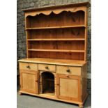 A reclaimed stripped and waxed pine farmhouse kitchen dresser, the base enclosed by a pair of