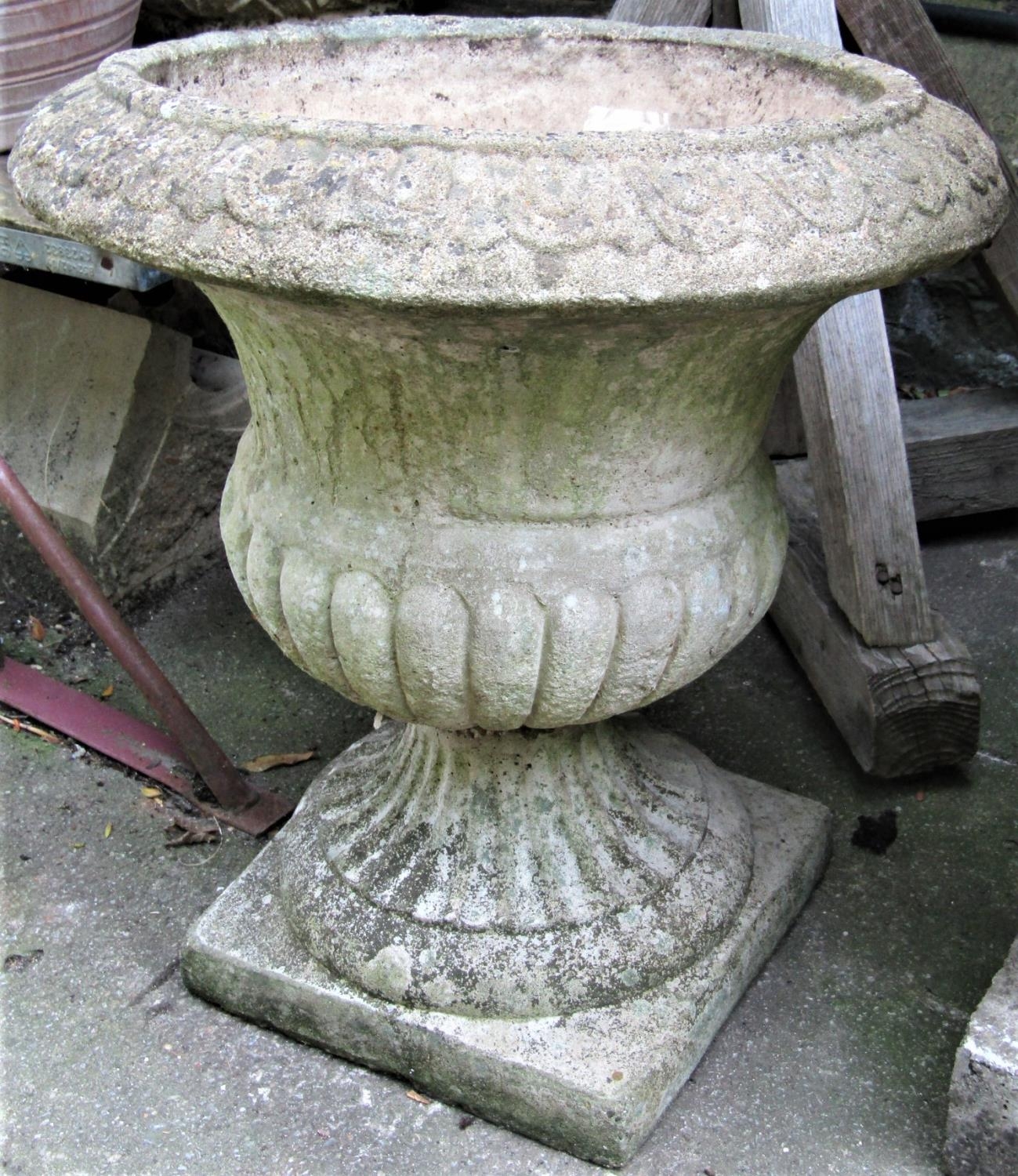 A reclaimed garden urn with flared egg and dart rim, lobed body and square cut base, 52cm diameter x
