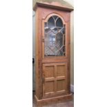 A Georgian pine side cupboard, the lower section enclosed by a quarter panelled door, the upper