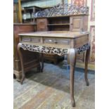 A 19th century Chinese hardwood writing desk raised on four shaped supports, enclosing two frieze