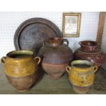 A circular treen charger, two early terracotta pots with yellow ground ochre finish, two further