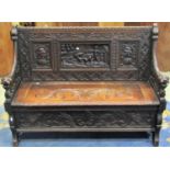 A 19th century carved oak hall box settle with lions mask arms, portrait and landscape panels and