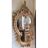 A shield shaped wall mirror with bevelled edge plate within a C scroll gilt frame, 110 cm x 58 cm