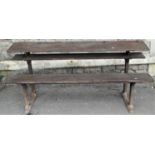 An antique school desk for four pupils, stepped form, with stained pine plank seat and adjustable