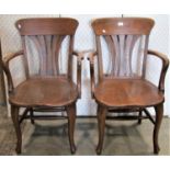 A pair of early 20th century oak office desk chairs with shaped/fan splats, open arms and saddle