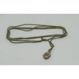 Antique gilt metal long guard chain with attached yellow metal locket with star-cut paste and seed