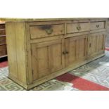 An old reclaimed stripped pine farmhouse kitchen dresser enclosed by three rectangular twin panelled