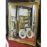 A large contemporary antique style wall mirror of rectangular form with bevelled edge plate within a