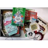 A box containing mixed football and some rugby ephemera including programs, rosettes, tickets,
