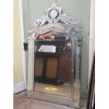 A Venetian style wall mirror with carved central looking glass, within an etched and bevelled
