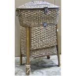 A wicker floorstanding sewing/work box of oval form with hinged lid and fall front with padded