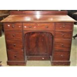 A 19th century mahogany desk fitted with an arrangement of nine frieze drawers of graduated size