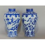 A pair of Chinese inverted baluster shaped vases with blue and white repeating detail, 23cm high