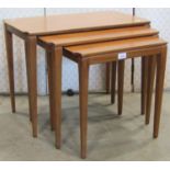 A nest of three teak graduated occasional tables with rectangular tops raised on slender square
