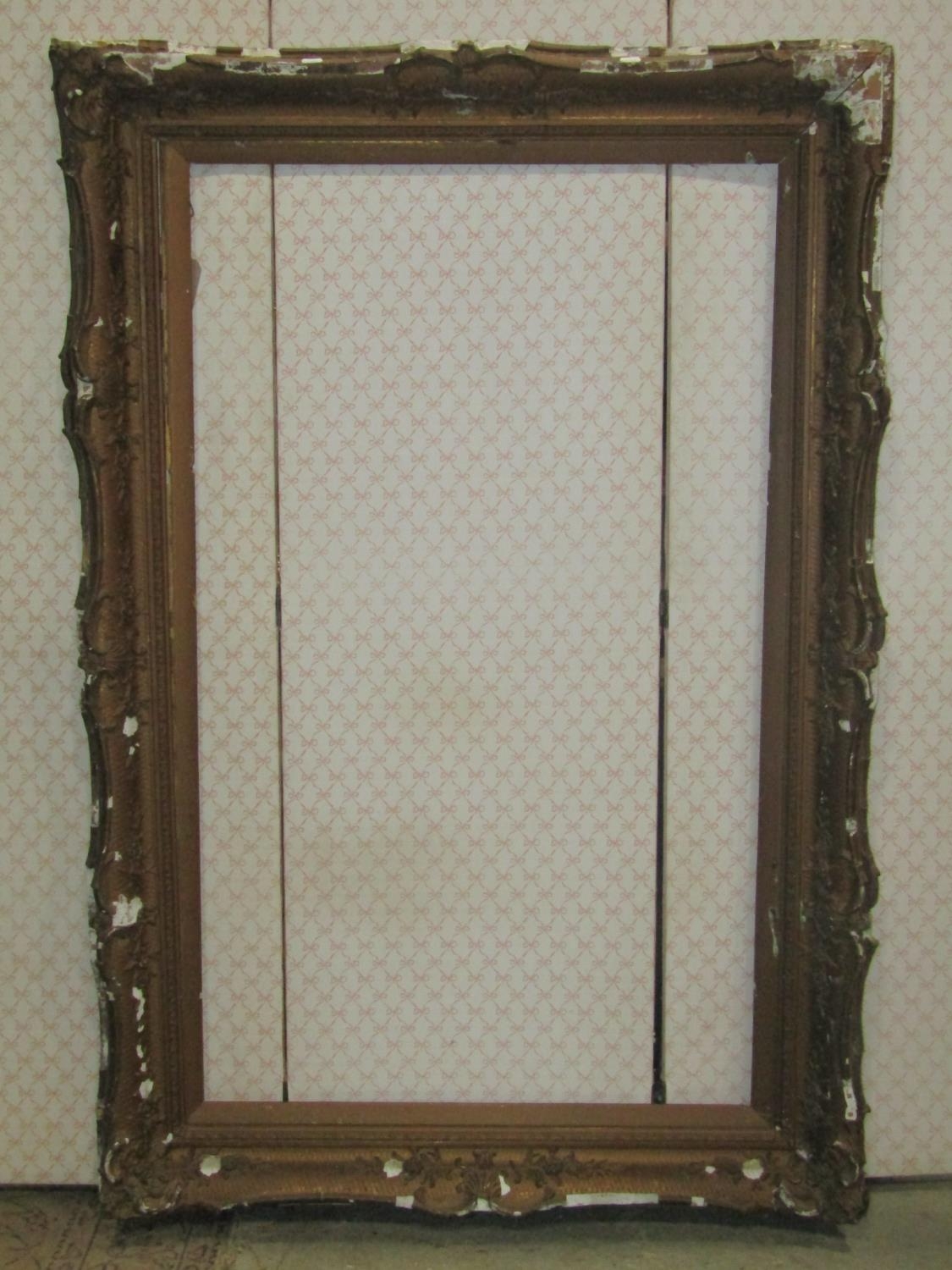 A large 19th century swept and moulded gilt frame with shell and foliate detail, 107cm x 157cm (