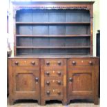 An early 19th century North Wales breakfront dresser in oak the base fitted with a T shaped